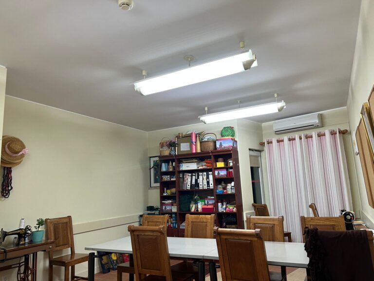 mesa com várias cadeiras e estantes com livros e objetos decorativos numa biblioteca/área de convívio do Lar João Gonçalves Palmeiro o Novo